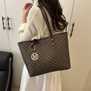 Classic brown monogram tote bag with gold M pendant and stylish shoulder straps