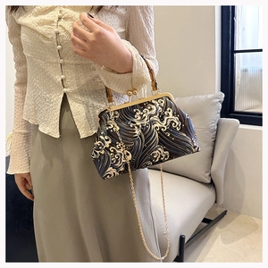 Detail of vintage frame bag with bamboo handle and blue wave pattern embroidery