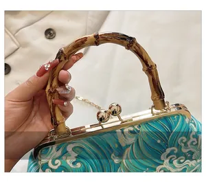 Detail of retro wave pattern fabric handbag with bamboo handle and gold metal clasp