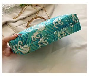 Detailed close-up of the reinforced bottom stitching of this wave print bamboo handle bag