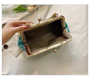 Detail view of the spacious inner compartment with zipper pocket and metal kiss-lock closure