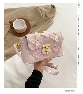 Detail of embroidered 3D butterflies and CD gold buckle on pink leather crossbody bag