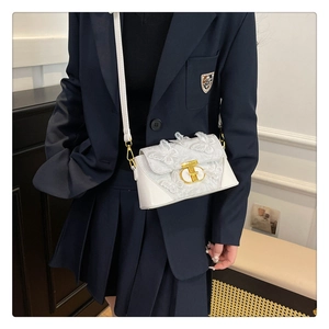 Detailed view of white lace crossbody bag with butterfly embroidery and gold metal clasp