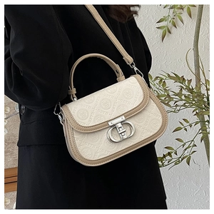 Dettaglio del motivo GSTH goffrato e fibbia in metallo CD su borsa a sella beige