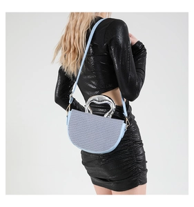 Detail of light blue saddle bag with woven texture and irregular silver metal handle
