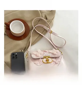 Detail of pink embroidered butterfly crossbody bag with gold lock and lace texture