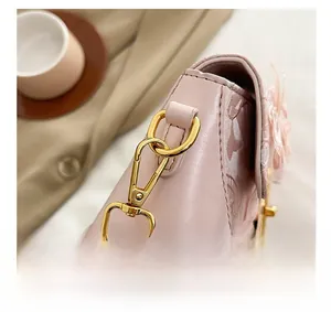 Detail of pink leather handbag showing floral lace accents and gold lobster clasp