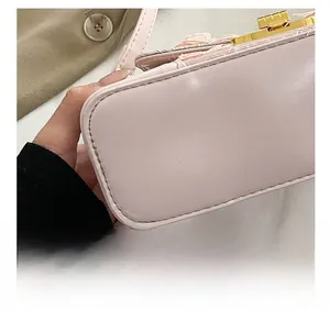 Detailed shot of pink leather bag bottom showing precision stitching and gold hardware