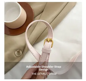 Detail of adjustable pink faux leather shoulder strap with golden buckle and stitching