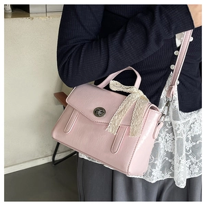 Dettaglio della borsa quadrata rosa chiaro con fiocco in pizzo e chiusura a scatto in metallo