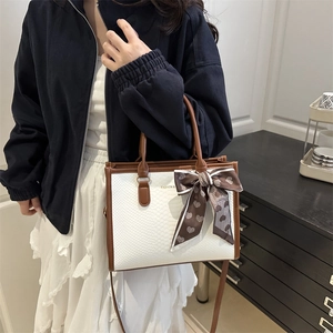White crocodile pattern tote bag with brown handles and a heart print silk scarf detail