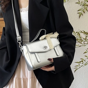 Borsa a tracolla argento metallizzato con fiocco in pizzo indossata da una modella