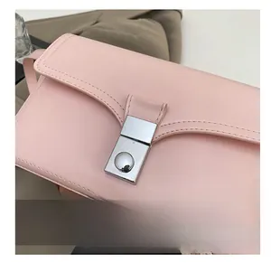 Detailed close-up of the silver metal clasp and fine stitching on the pink leather bag