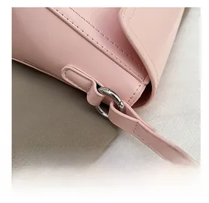 Detail of pink faux leather shoulder bag featuring premium silver metal strap rings