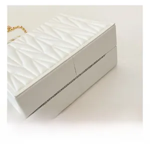 Macro detail of geometric quilted stitching on white structured chain box clutch