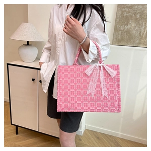 Detail der rosa Jacquard-Tragetasche mit rotem Doppeltem-Glück-Motiv und Spitzenschleife