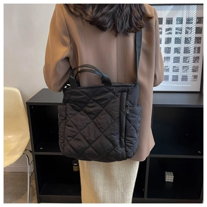 Rear view of a model wearing a black quilted tote bag with versatile shoulder straps