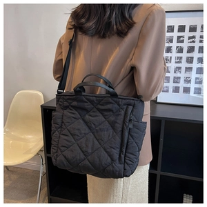 Detailed view of the large black quilted tote bag with diamond lattice pattern