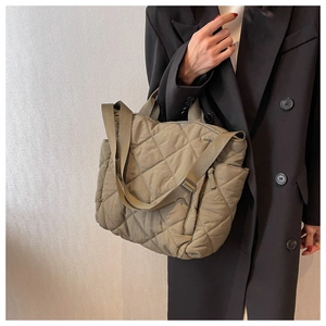 Detail of olive green quilted tote bag with diamond pattern and adjustable shoulder strap