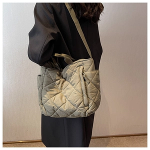 Detail view of large quilted olive tote bag showing diamond stitch and wide strap