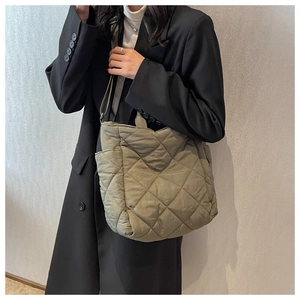 Side view of olive green quilted tote bag showing large capacity on model