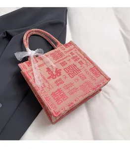 Detailansicht der rosa Canvas-Einkaufstasche mit 囍-Symbolen und weißer Spitzenschleife