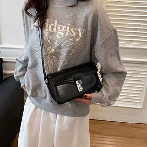Minimalist black PU leather crossbody bag with silver buckle worn by a model
