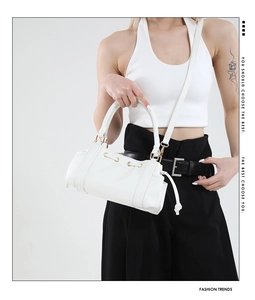 Minimalist white leather tote bag with drawstring detail and gold hardware on model