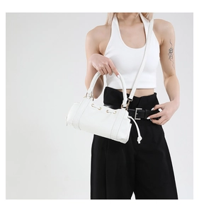 Close-up of white barrel handbag with gold hardware and drawstring detail
