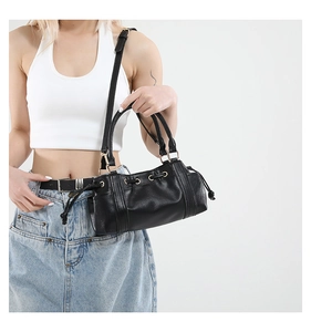 Detail view of black Boston bag with drawstring pleats and adjustable strap on model