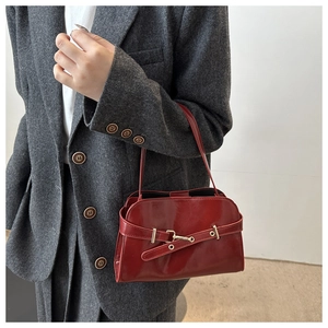 Dettaglio della borsa retrò in pelle verniciata rosso scuro con fibbia in metallo lucido
