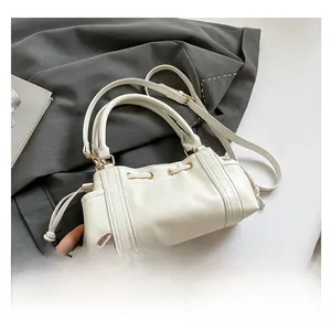 Detail of off-white PU leather handbag featuring gold-plated hardware and side drawstrings