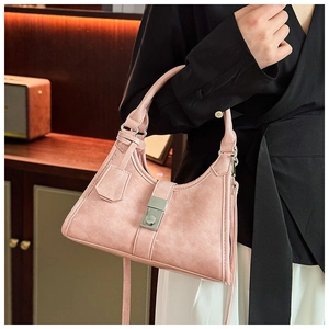 Detailed close-up of pink textured leather handbag with a silver square clasp buckle