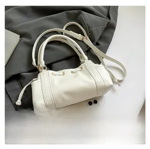 White lychee leather tote bag with drawstring detail and smartphone for size reference
