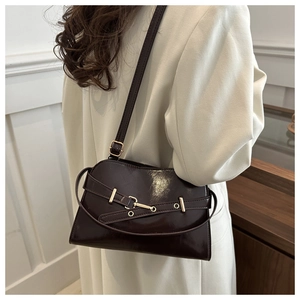 Dettaglio della borsa sottobraccio vintage in pelle lucida marrone con fibbia dorata