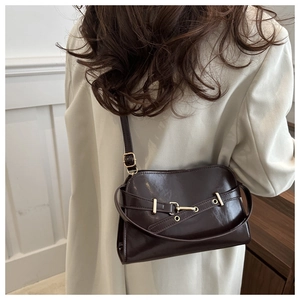 Dettaglio ravvicinato della borsa vintage marrone scuro con fibbia e tracolla in pelle