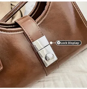 Close-up of silver square metal clasp and rich caramel brown oily leather texture