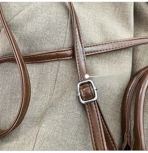 Detail of glossy brown leather strap with silver adjustable metal buckle and stitching