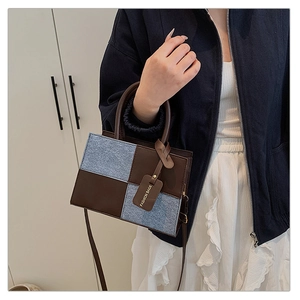 Dettagli in denim blu e pelle marrone su questa borsa a mano vintage da donna