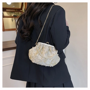 Detail of white satin shell bag with gold butterfly embroidery and pearl chain strap