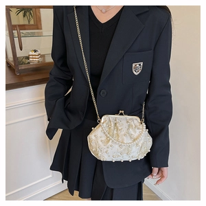 Detail of vintage floral embroidery and heavy pearl beading on shell crossbody bag