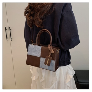 Dettaglio borsa a tracolla trendy con pelle marrone e trama a scacchi blu