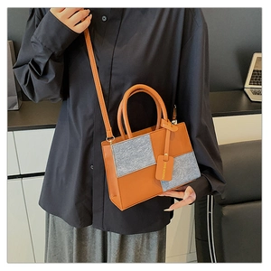 Dettaglio borsa color-block in pelle arancione, tweed grigio e targhetta Fashion Bags