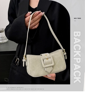 Detail of the light khaki denim baguette bag with a bold square buckle and gold hardware