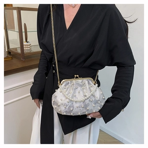 Detail of beaded shell clutch bag featuring pearl embellishments and butterfly print