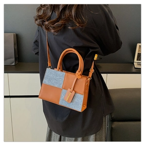 Dettaglio della borsa patchwork con pelle arancione e texture in feltro grigio