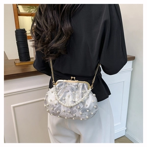 Detail of floral jacquard bag with white pearl embellishments and a metal chain strap