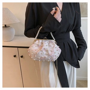 Detailed view of pink floral pearl cloud bag with gold chain strap on a model