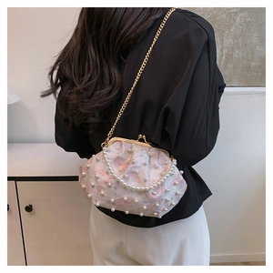 Detail of pink floral bag with butterfly prints, pearl accents and gold metal chain