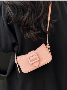 Detail of pink fabric baguette bag with large square buckle and gold hardware